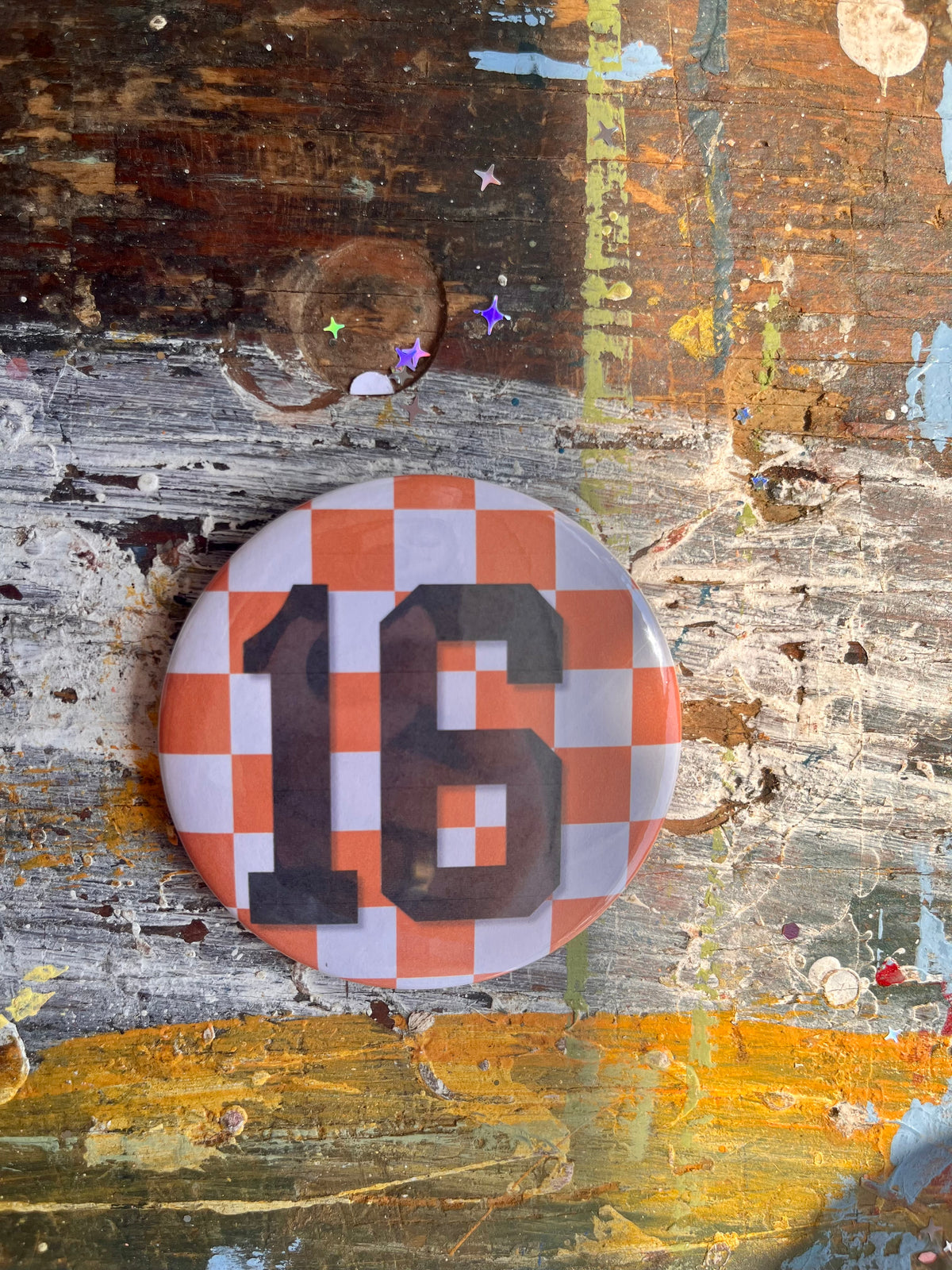 "16" on orange/white check button
