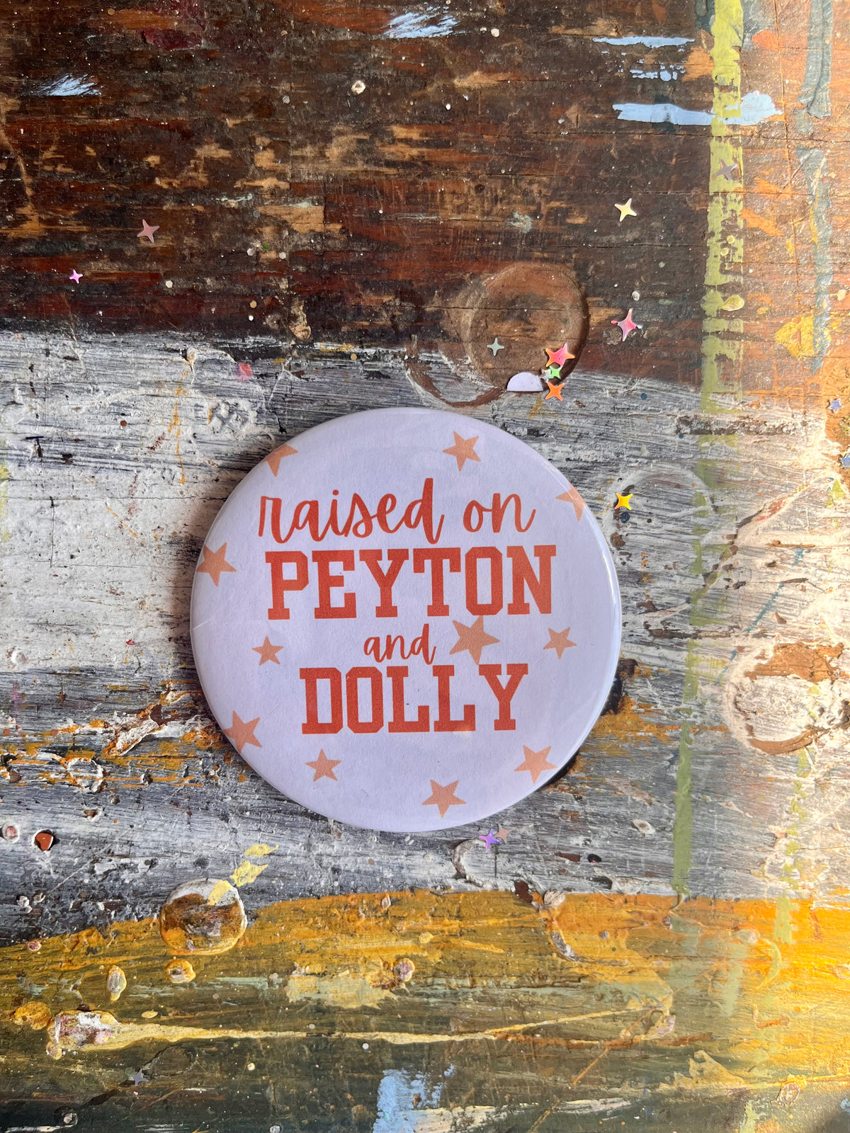 "raised on PEYTON and DOLLY" orange with stars button