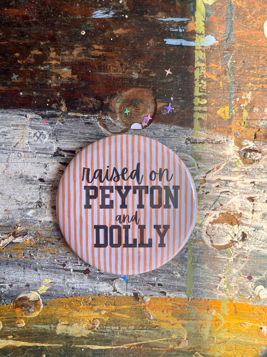"raised on PEYTON and DOLLY" black on orange/white stripes button