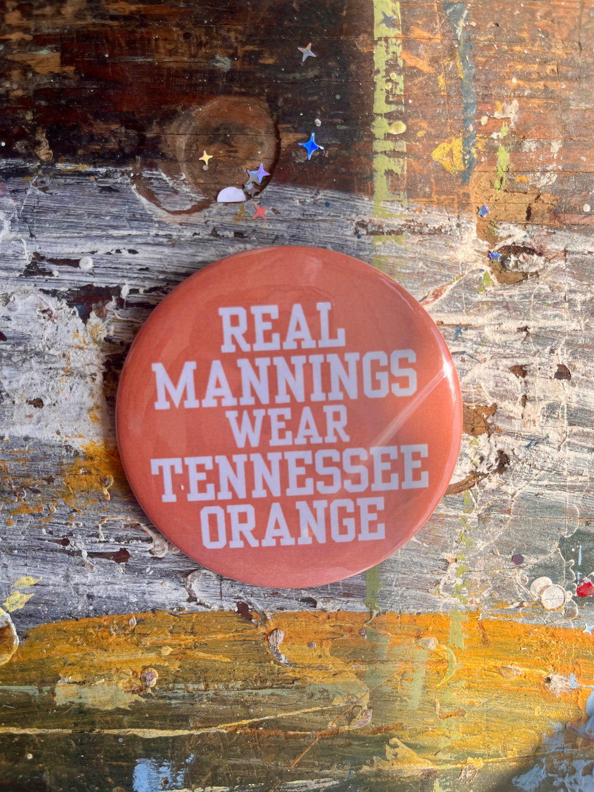 "REAL MANNINGS WEAR TENNESSEE ORANGE" white letters on orange button